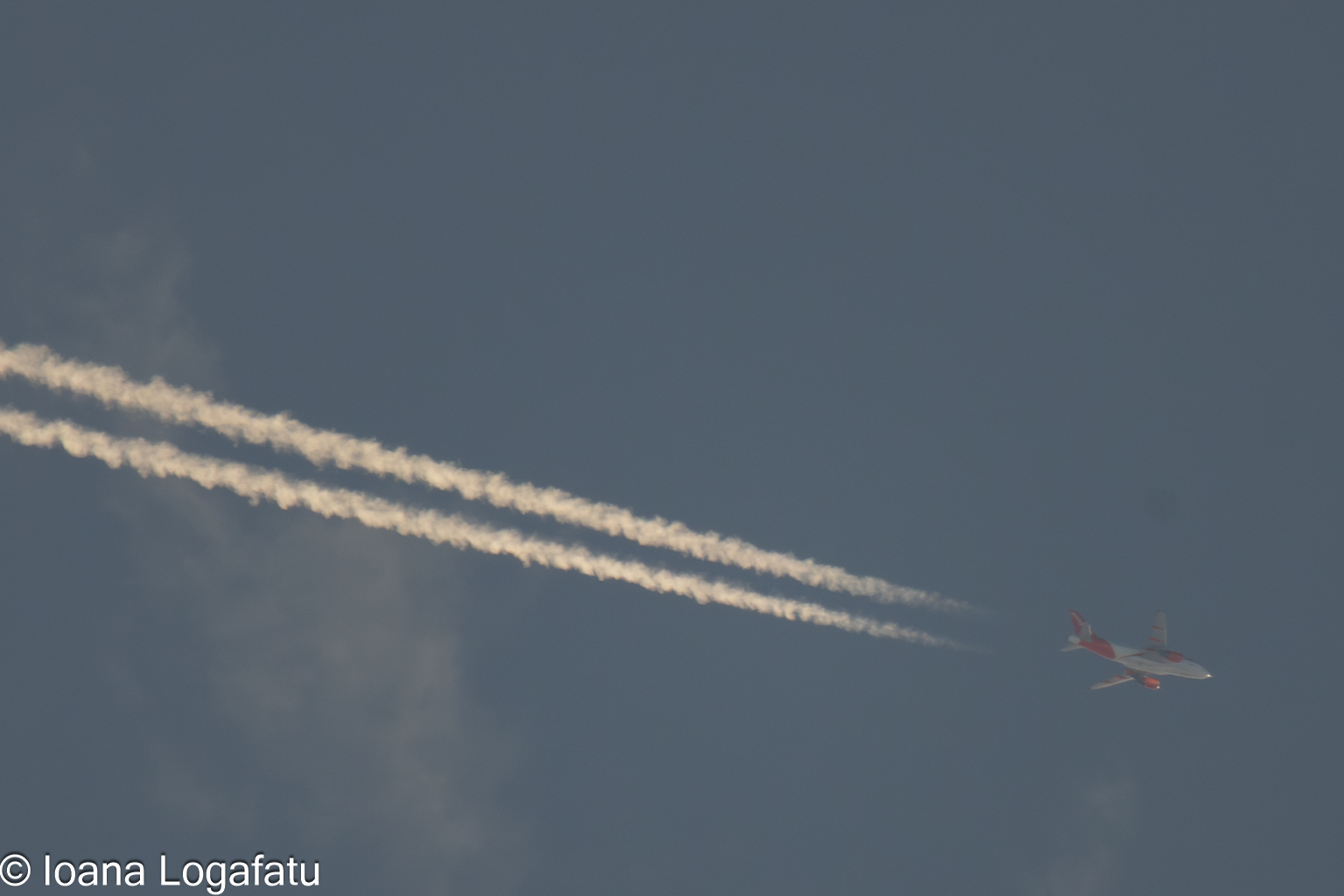 Contrails gliding through a vast blue sky